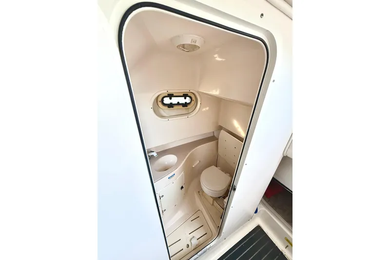 Slide: The Image of 2003 Pursuit 2870 Walkaround boat interior bathroom with toilet and sink. - 18