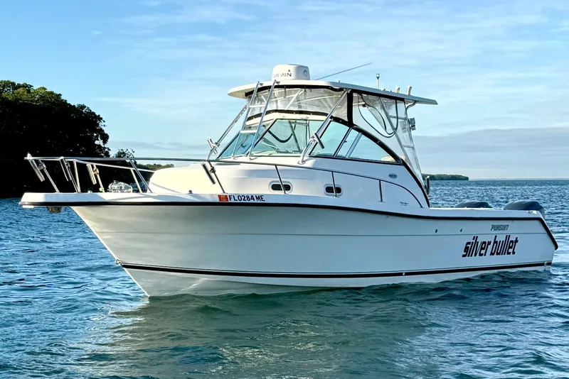 Slide: The Image of 2003 Pursuit 2870 Walkaround boat named "Silver Bullet" on calm water. - 2