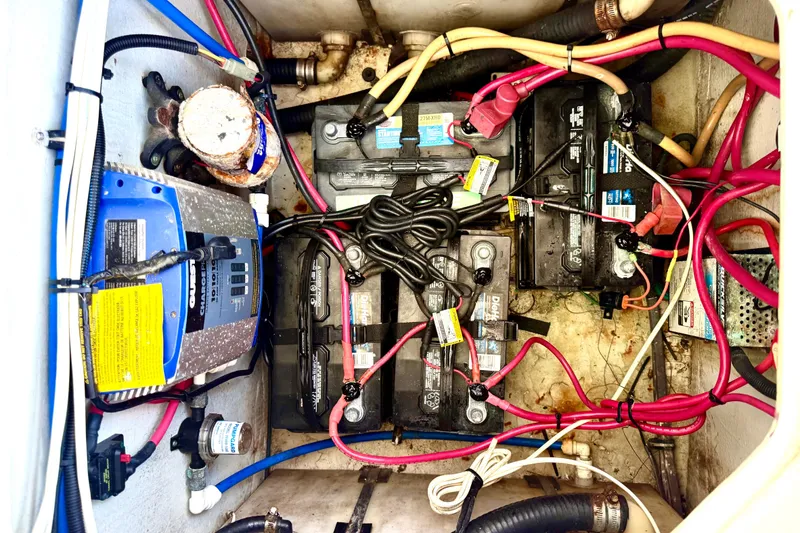 Slide: The Image of 2003 Pursuit 2870 Walkaround boat battery compartment with wiring and charger. - 20