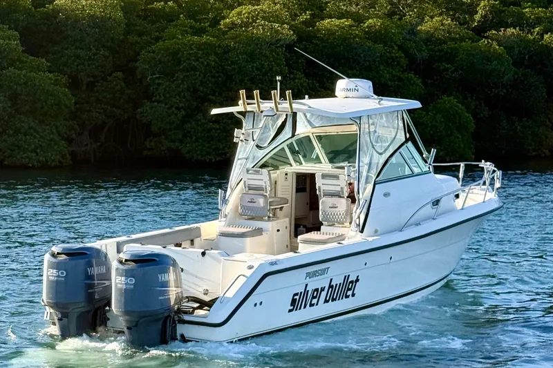 Slide: The Image of 2003 Pursuit 2870 Walkaround boat with twin Yamaha engines on water. - 3