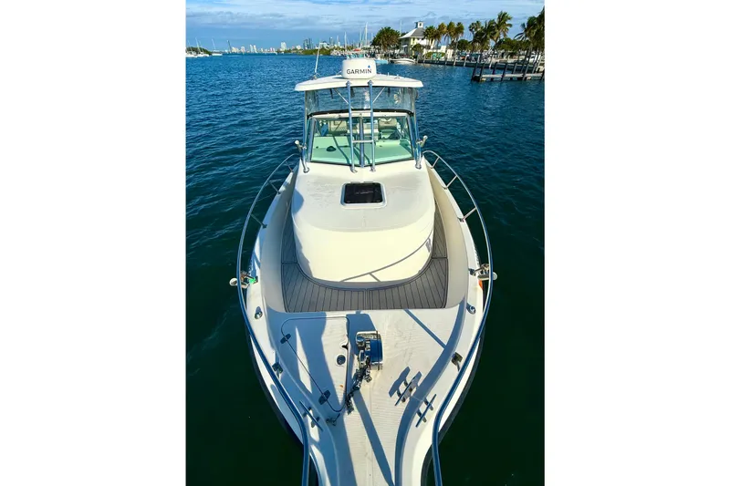 Slide: The Image of 2003 Pursuit 2870 Walkaround boat on calm water, clear sky, and distant shoreline. - 5