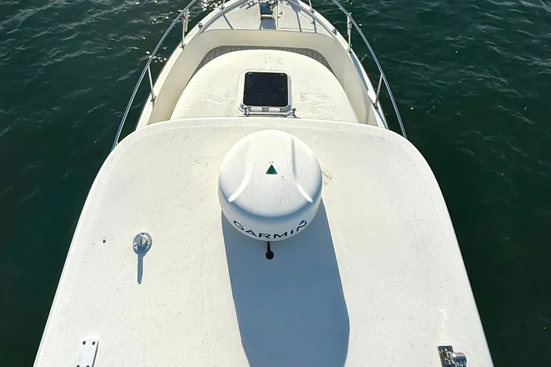 Slide: The Image of 2003 Pursuit 2870 Walkaround boat deck with Garmin equipment on calm water. - 7