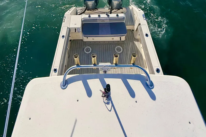 Slide: The Image of 2003 Pursuit 2870 Walkaround boat deck with rod holders on open water. - 8