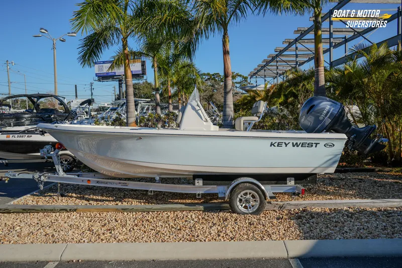 Slide: The Image of 2026 Key West 188 Bay Reef boat on trailer, displayed outdoors with palm trees. - 2