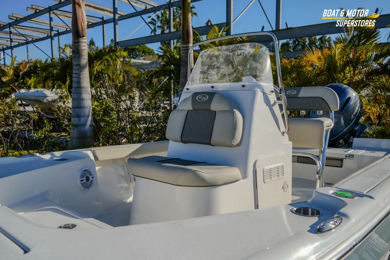 Slide: The Image of 2026 Key West 188 Bay Reef boat with seating and console, displayed outdoors. - 8