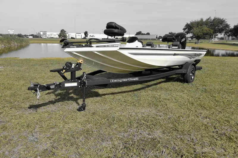 Slide: The Image of 2026 Ranger RT188 boat on trailer, parked on grass near a pond. - 2