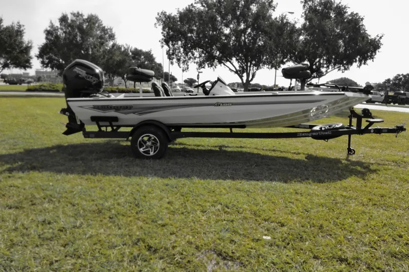 Slide: The Image of 2026 Ranger RT188 boat on trailer, parked on grass with trees in background. - 7
