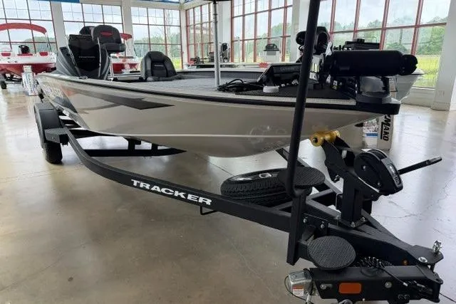 Slide: The Image of 2026 Tracker Savage 215 boat on trailer in showroom, featuring sleek design and modern equipment. - 5