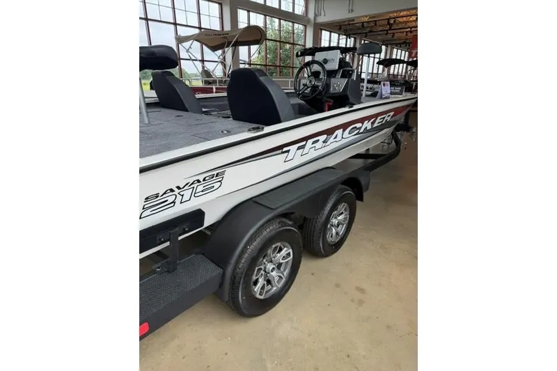 Slide: The Image of 2026 Tracker Savage 215 boat on trailer in showroom setting. - 4