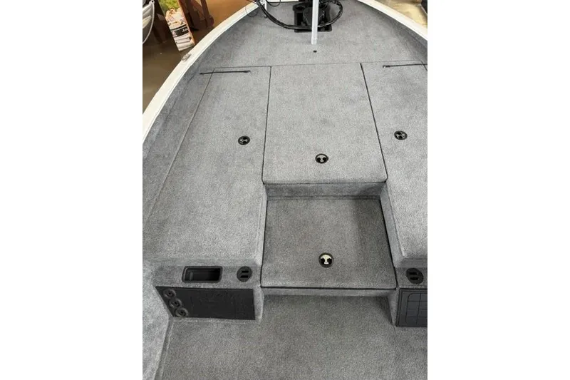 Slide: The Image of 2026 Tracker Savage 215 boat interior with gray carpeted deck and storage compartments. - 13