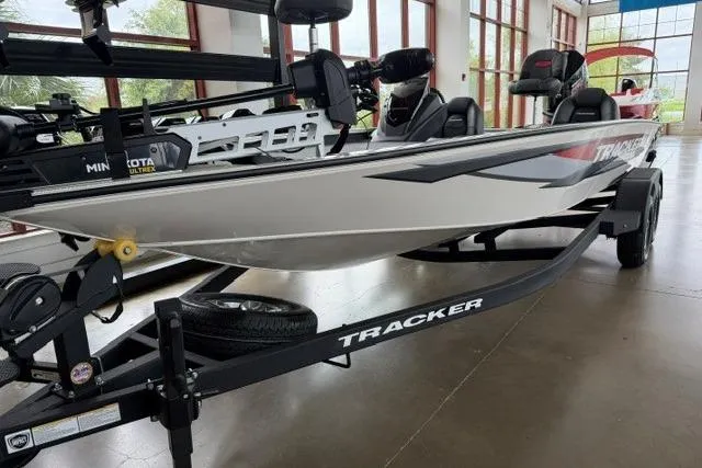 Slide: The Image of 2026 Tracker Savage 215 boat on display in a showroom. - 6