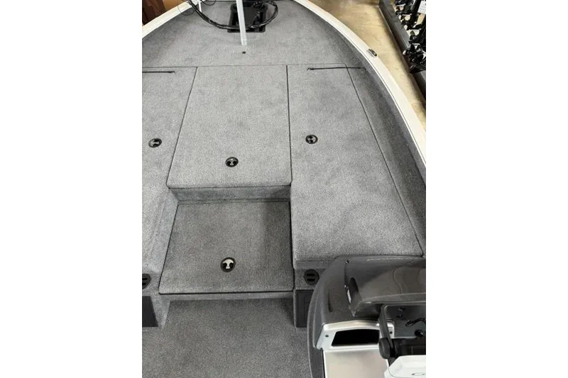 Slide: The Image of 2026 Tracker Savage 215 boat interior with gray carpeted deck and storage compartments. - 16