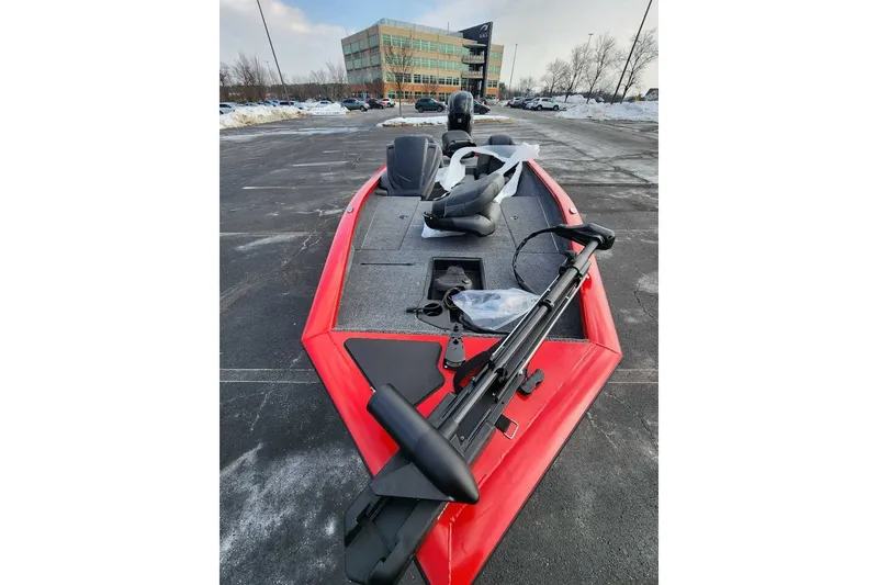 The Image of 2026 Tracker Pro Team 175 boat in parking lot, red exterior, snowy surroundings. - 0