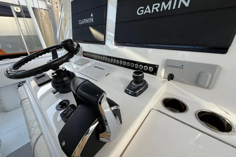 Slide: The Image of 2024 Contender 44 ST boat dashboard with Garmin navigation system and steering wheel. - 13