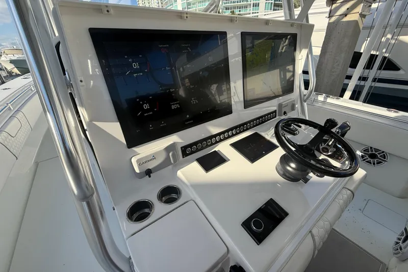 Slide: The Image of 2024 Contender 44 ST boat dashboard with dual screens and steering wheel. - 15