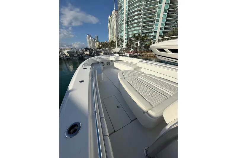 Slide: The Image of 2024 Contender 44 ST boat docked, featuring sleek design and luxurious seating. - 19