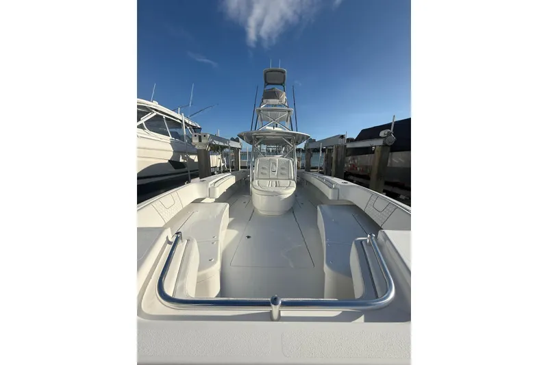 Slide: The Image of 2024 Contender 44 ST boat docked, showcasing spacious deck and sleek design under clear blue sky. - 21