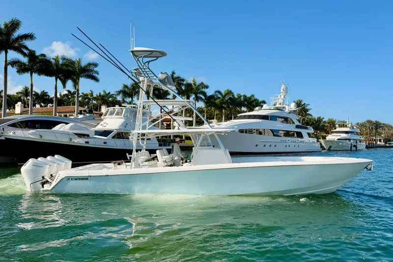 Slide: The Image of 2024 Contender 44 ST boat on water, surrounded by yachts and palm trees. - 27