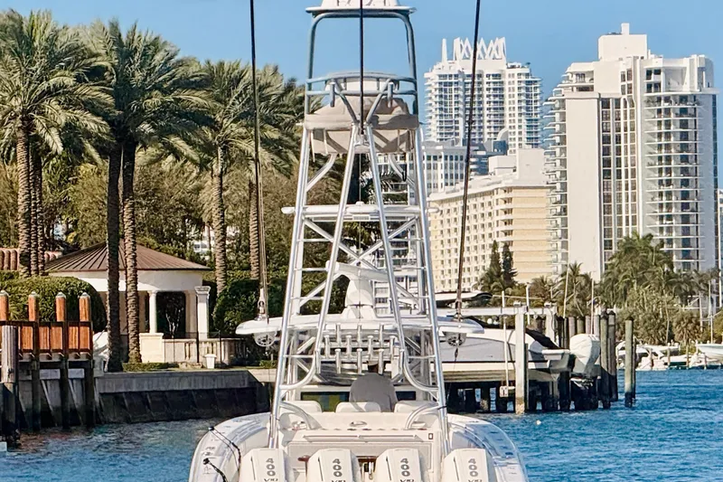 Slide: The Image of 2024 Contender 44 ST boat docked in a marina with palm trees and city skyline. - 30