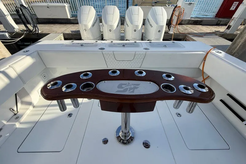 Slide: The Image of 2024 Contender 44 ST boat with quad engines, spacious deck, and fishing rod holders. - 7