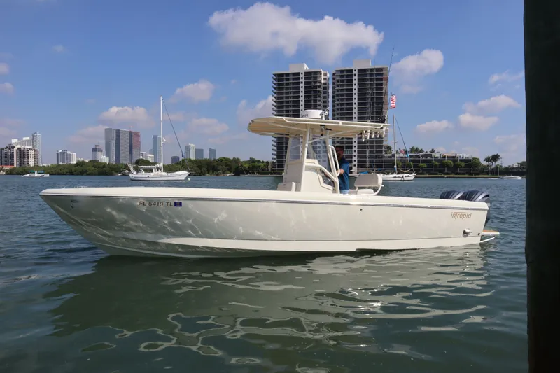 Slide: The Image of 2002 Intrepid 289 Open boat on calm water with city skyline. - 1