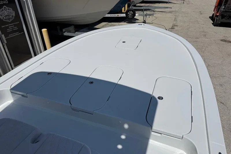 Slide: The Image of 2026 Shallow Sport 25 X3 boat deck with storage compartments in a marina setting. - 20