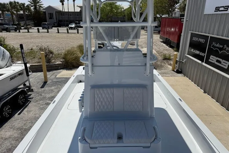 Slide: The Image of 2026 Shallow Sport 25 X3 boat with seating and console, parked outdoors. - 22