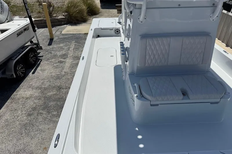 Slide: The Image of 2026 Shallow Sport 25 X3 boat interior with cushioned seating and spacious deck. - 23
