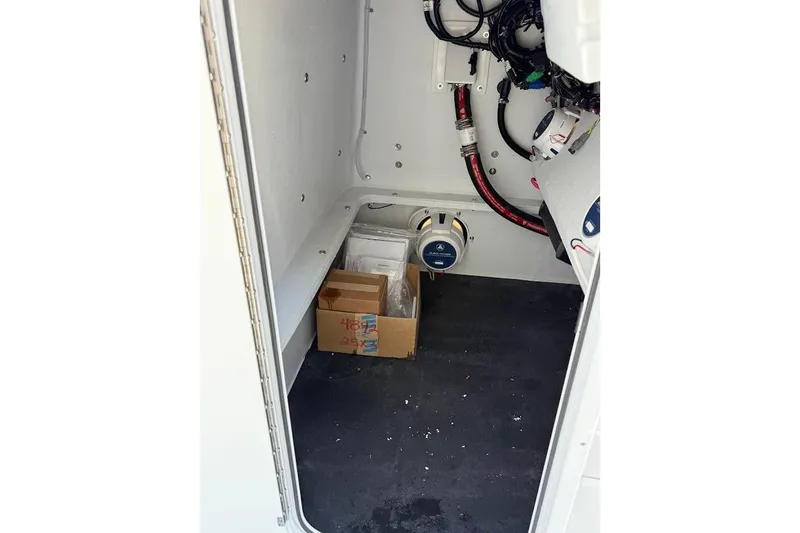 Slide: The Image of Interior view of 2026 Shallow Sport 25 X3 boat compartment with wiring and equipment. - 25