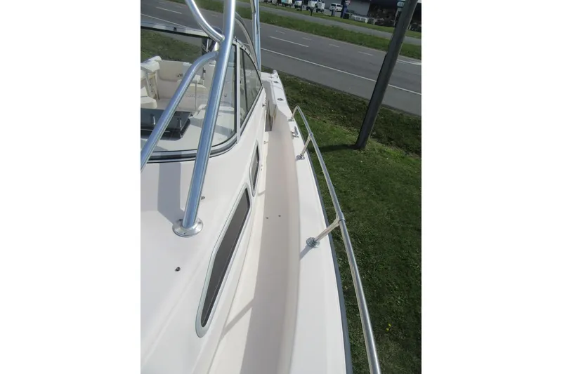 Slide: The Image of 1996 Grady-White Voyager 248 boat deck with railing, parked near a road. - 14