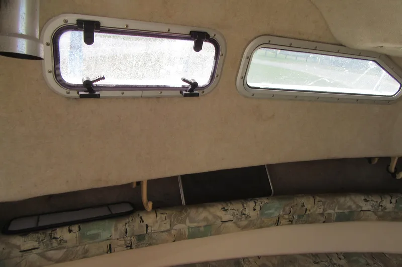 Slide: The Image of Interior cabin view of a 1996 Grady-White Voyager 248 boat, featuring windows and seating. - 17