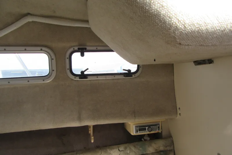Slide: The Image of Interior cabin view of a 1996 Grady-White Voyager 248 boat, featuring windows and upholstery. - 21