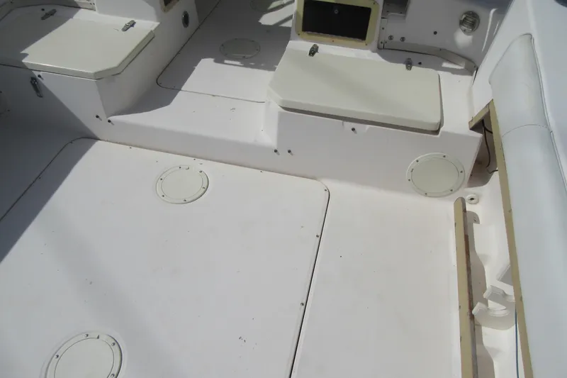 Slide: The Image of 1996 Grady-White Voyager 248 boat interior with white seating and storage compartments. - 35