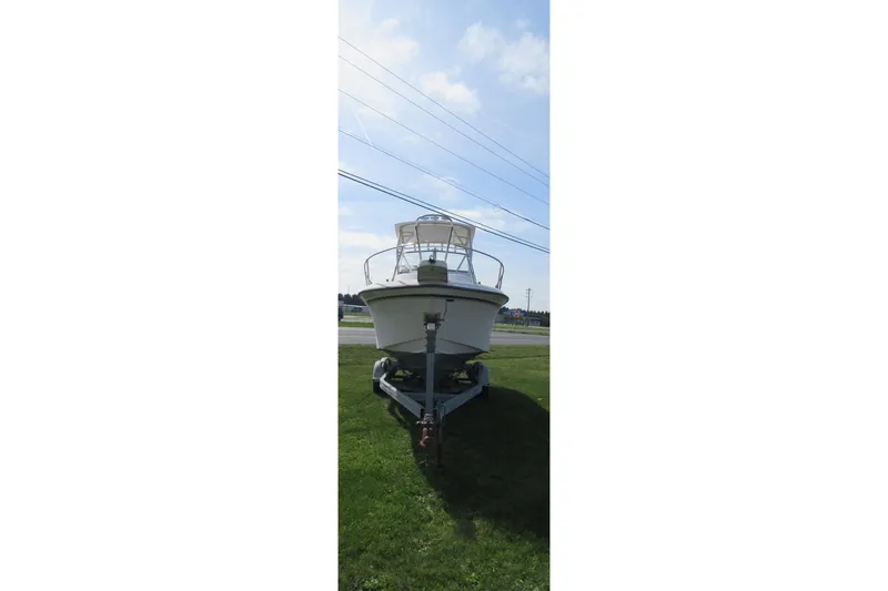 Slide: The Image of 1996 Grady-White Voyager 248 boat on trailer, parked on grass under blue sky. - 5