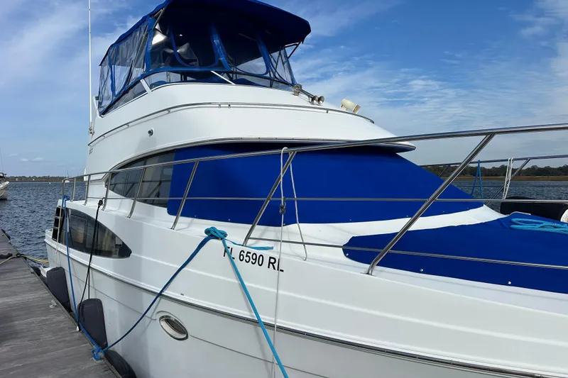 Slide: The Image of 2005 Carver 36 Super Sport yacht docked with blue canopy and railing. - 10