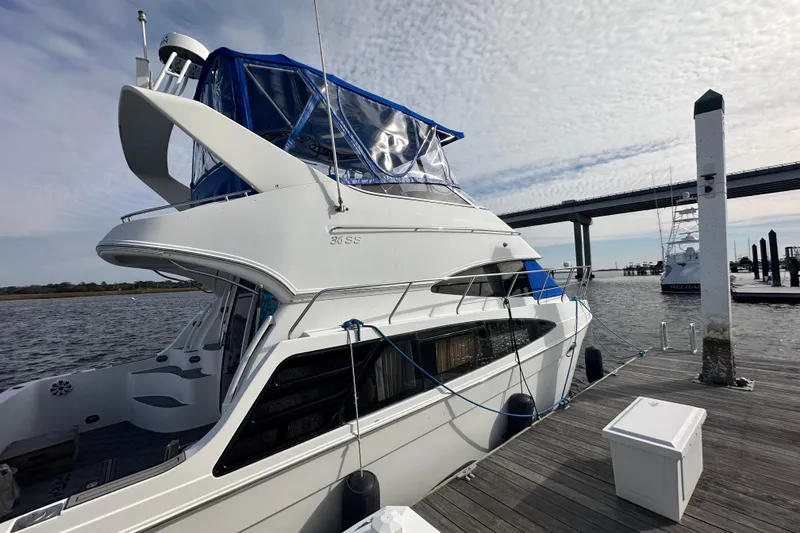 Slide: The Image of 2005 Carver 36 Super Sport yacht docked at marina with bridge in background. - 11