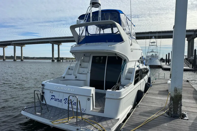 Slide: The Image of 2005 Carver 36 Super Sport yacht docked by a bridge on a sunny day. - 12