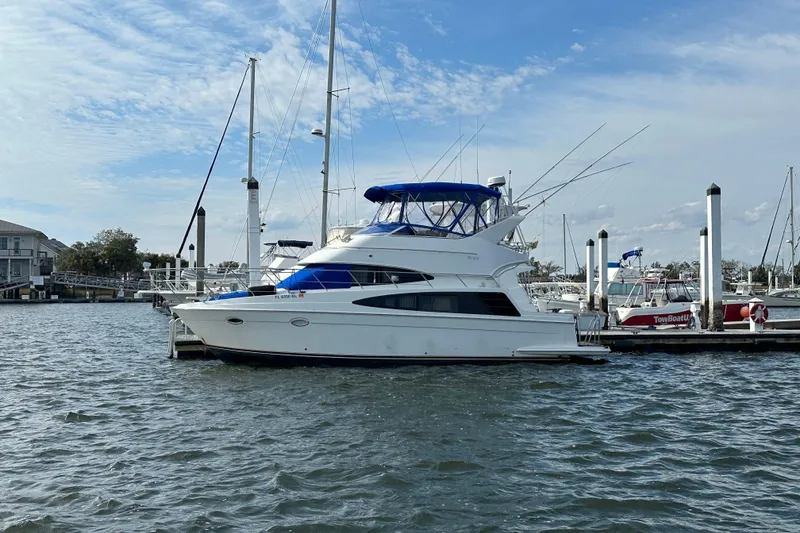 Slide: The Image of 2005 Carver 36 Super Sport yacht docked at marina under blue sky. - 2