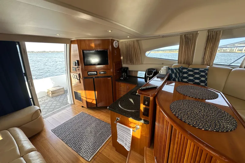 Slide: The Image of Interior of 2005 Carver 36 Super Sport yacht with elegant wood finishes and waterfront view. - 29