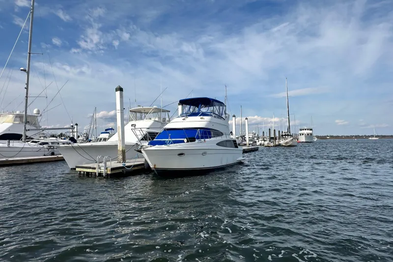 Slide: The Image of 2005 Carver 36 Super Sport yacht docked in a marina under a clear blue sky. - 4