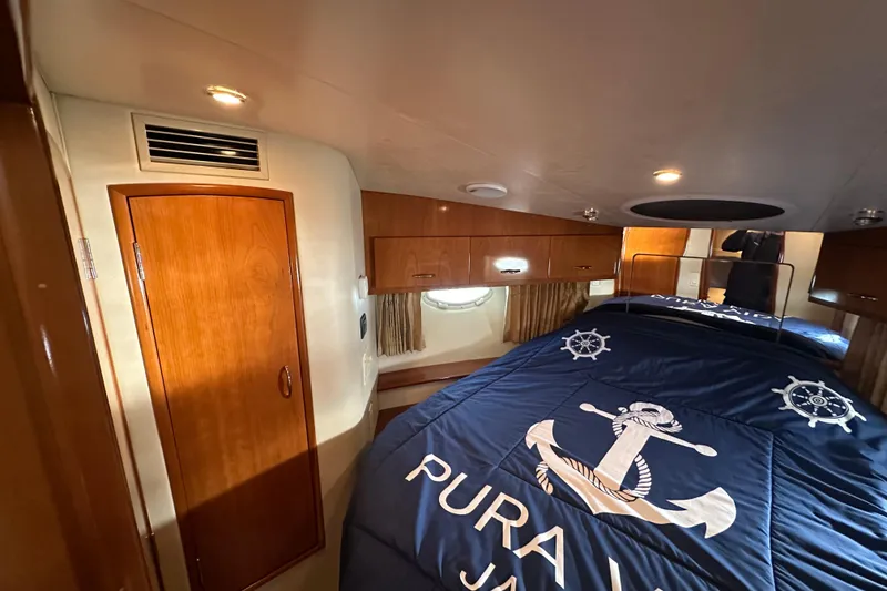 Slide: The Image of 2005 Carver 36 Super Sport cabin with nautical-themed bedding and wooden cabinetry. - 41