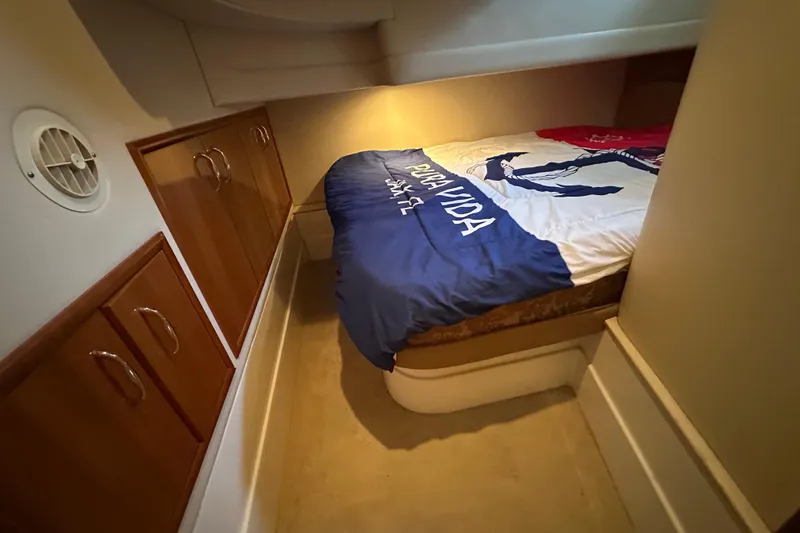 Slide: The Image of 2005 Carver 36 Super Sport cabin with bed and wooden storage cabinets. - 45