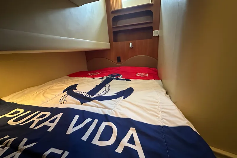 Slide: The Image of Cozy cabin bed in 2005 Carver 36 Super Sport yacht with nautical-themed bedding. - 47