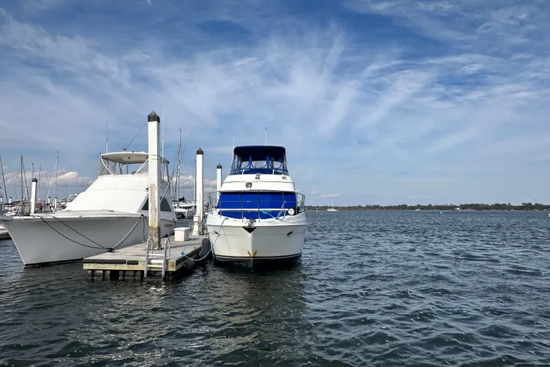 Slide: The Image of 2005 Carver 36 Super Sport yacht docked at marina under blue sky. - 5
