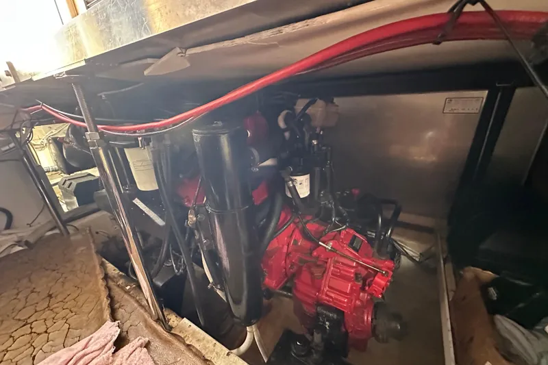 Slide: The Image of Engine compartment of a 2005 Carver 36 Super Sport boat, featuring red engine components. - 52