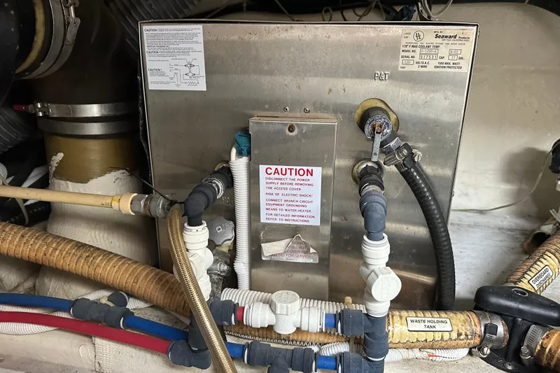 Slide: The Image of Engine room of 2005 Carver 36 Super Sport with plumbing and caution labels. - 66