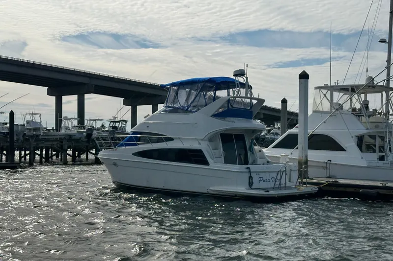 Slide: The Image of 2005 Carver 36 Super Sport yacht docked near a bridge on a cloudy day. - 7