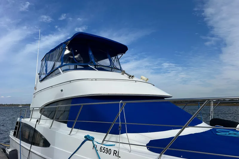 Slide: The Image of 2005 Carver 36 Super Sport yacht docked under a clear blue sky. - 9
