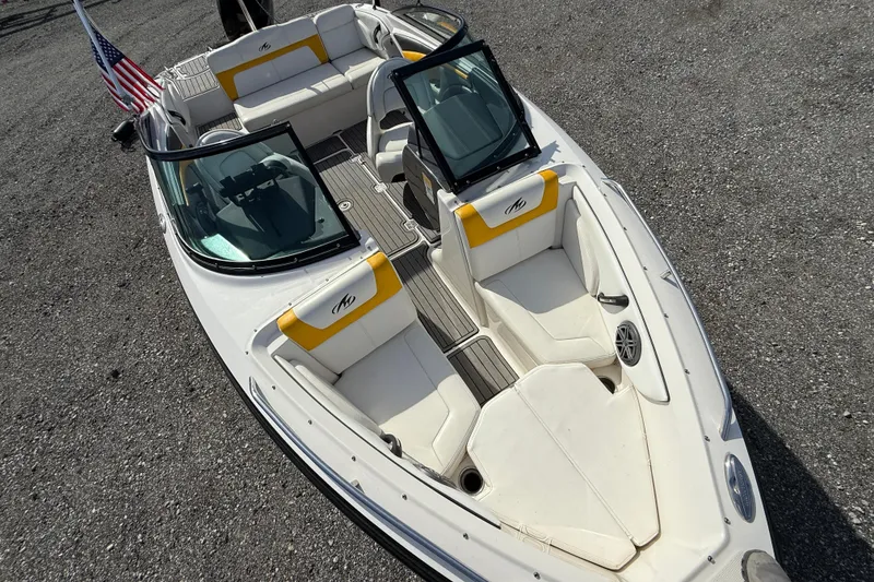 Slide: The Image of 2014 Monterey 197 Blackfin boat with white and yellow seating, American flag displayed. - 16
