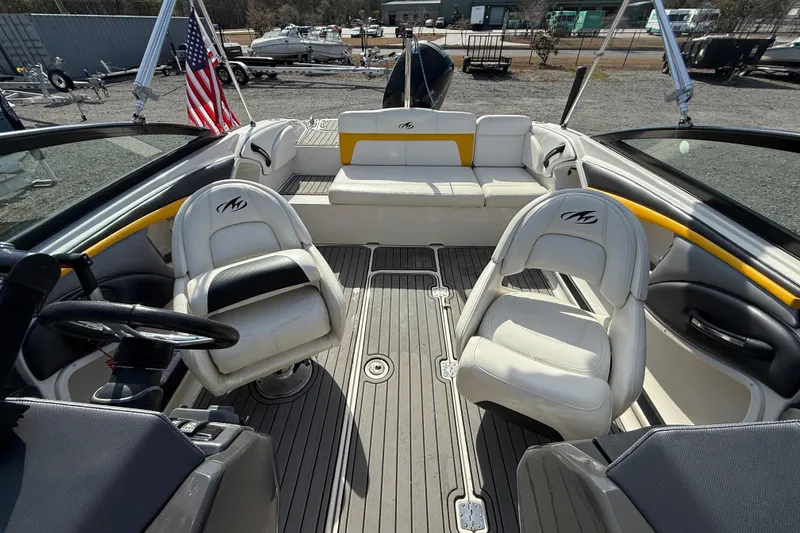 Slide: The Image of 2014 Monterey 197 Blackfin boat interior with seating and steering wheel, docked outdoors. - 22